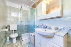 a bathroom with a toilet and a sink and a shower at Rooms Nadica in Baška +70 photos