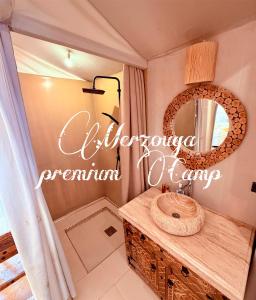 a bathroom with a sink and a mirror at Merzouga premium Camp in Merzouga +46 photos