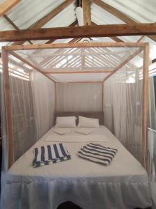 a bed in a tent with two towels on it at Upali Beach Surf Resort in Nikawatawana +10 photos