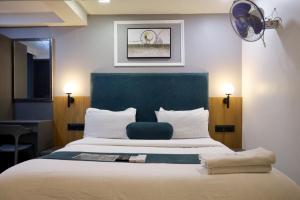 a bedroom with a large bed with a blue headboard at HOTEL GOLD LEAF in Ahmedabad