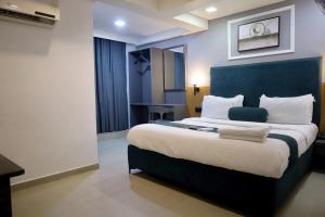 a bedroom with a large bed with a blue headboard at HOTEL GOLD LEAF in Ahmedabad