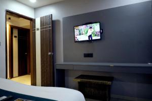 a living room with a tv above a fireplace at HOTEL GOLD LEAF in Ahmedabad