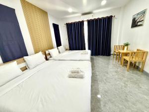 a hotel room with two beds and a table at Bonus Pool Villa Chiang Mai in Chiang Mai +39 photos