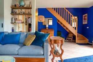 a living room with blue walls and a blue couch at La Maison Bleue in Rustrel