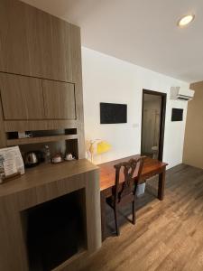 a room with a desk and a table and a chair at Palette - Bukit Mata Boutique Hotel in Kuching