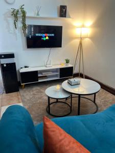 a living room with a blue couch and a tv at TULIVU Homes in Mombasa