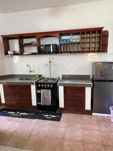 a kitchen with black appliances and brown cabinets at TULIVU Homes in Mombasa