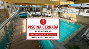 a sign is posted in front of a swimming pool at Apart Sorrento in Santa Teresita
