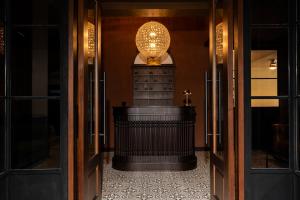 a hallway with a table and a chandelier at Merchant's Gate Songwat in Bangkok