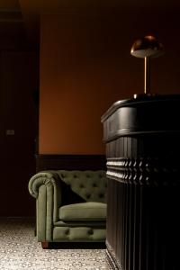 a green couch in a room with a lamp at Merchant's Gate Songwat in Bangkok +16 photos