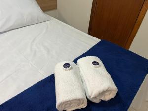 two towels are sitting on a bed at Studio-type apartment in Praia do Forte in Mata de Sao Joao