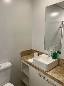 a bathroom with a white sink and a mirror at Studio-type apartment in Praia do Forte in Mata de Sao Joao