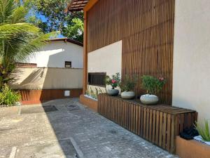 a patio with three vases on a wooden fence at Studio-type apartment in Praia do Forte in Mata de Sao Joao +13 photos