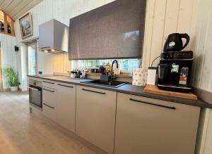 a kitchen with white cabinets and a counter top at Rūdupji Anna in Kalniena