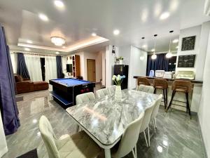 a dining room with a table and a pool table at Bonus Pool Villa Chiang Mai in Chiang Mai
