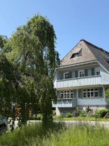 a large white house with a white fence at berg zeit in Hinterzarten in Hinterzarten