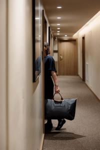 a woman walking down a hallway with a purse at Radisson Blu Hotel, Rouen Centre in Rouen