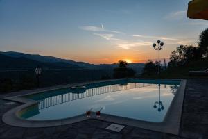 a swimming pool with a sunset in the background at Podere Vecci in Dicomano