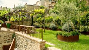 a garden with a fence and trees and plants at Wp Relais Mazzini in Montalcino