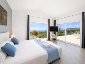 a white bedroom with a large bed and a balcony at The View in Tías +26 photos