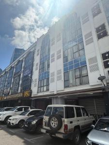 a large building with cars parked in a parking lot at Palette - Bukit Mata Boutique Hotel in Kuching