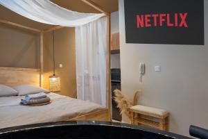 a bedroom with a bed with a netflix sign on the wall at Love Room avec Jacuzzi - Le cocon caché in Bressuire +1 photo