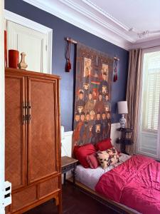 a bedroom with a bed and a painting on the wall at Appartement centre rennes in Rennes