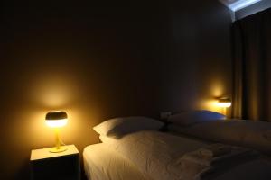 a bedroom with two beds and a lamp on a night stand at Blue Viking Studios in Keflavík