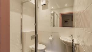 a white bathroom with a toilet and a sink at Dog Friendly Lakeland Cottage At Windermere Marina Village in Bowness-on-Windermere +14 photos