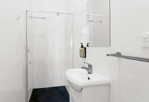 a white bathroom with a sink and a shower at Windsor Green Hotel in Melbourne +51 photos
