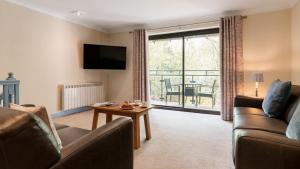 a living room with a couch and a table at Dog Friendly Lakeland Cottage At Windermere Marina Village in Bowness-on-Windermere