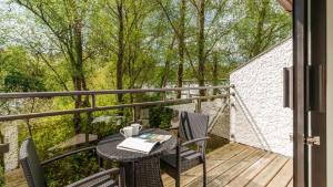 a balcony with a table and chairs on a deck at Dog Friendly Lakeland Cottage At Windermere Marina Village in Bowness-on-Windermere