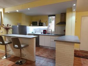 a kitchen with a counter and some chairs in it at El Rincón de Orión in Ciudad Real