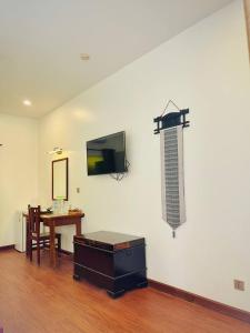 a room with a table and a tv on a wall at Savada Angkor Boutique Hotel in Siem Reap