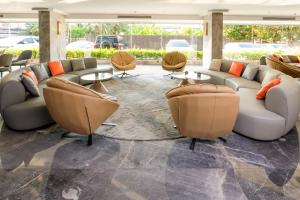 a lobby with a couch and chairs and tables at HK Hotel Bangkok in Ban Bang Toei (1)