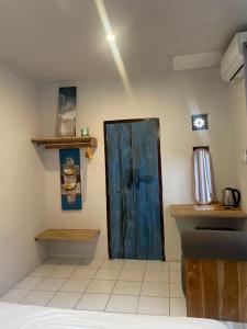 a room with a blue door on the wall at Pondok Gopi Room in Cemagi