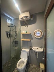 a bathroom with a toilet and a sink and a shower at Pondok Gopi Room in Cemagi