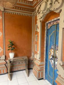 a room with a table and a painting on the wall at Pondok Gopi Room in Cemagi