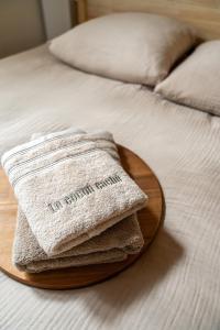 a wooden plate with towels on a bed at Love Room avec Jacuzzi - Le cocon caché in Bressuire