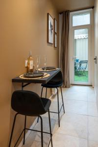 a dining table with two chairs and wine glasses at Love Room avec Jacuzzi - Le cocon caché in Bressuire