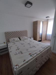 a bedroom with a large bed with a floral bedspread at Apartman Limski Kutak in Železnička Stanica Prijepolje