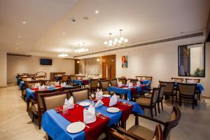 a restaurant with blue and red tables and chairs at Hotel Noble Residency in Kizhillam