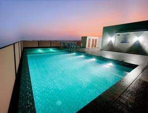 a swimming pool on the roof of a building at Hotel Noble Residency in Kizhillam