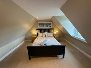 a bedroom with a large bed in a attic at Alt-Na-Slat Cottage in Invergarry