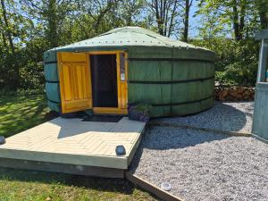 a green yurt with a wooden deck in a yard at Sheviock Barton Yurt in Sheviock +15 photos
