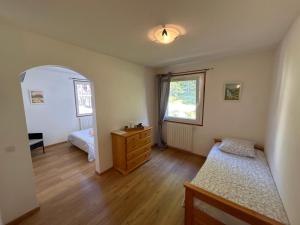 a bedroom with two beds and a dresser and a window at La bagatelle in Saint-Michel-de-Chaillol
