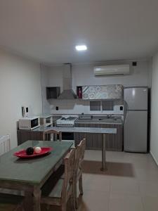a kitchen with a table and chairs and a refrigerator at Departamento juana con cochera in Rafaela