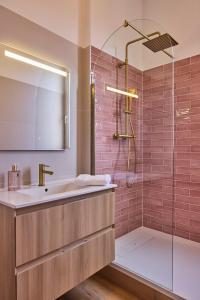 a bathroom with a sink and a shower with pink tiles at Haussmannien calme hyper-centre in Troyes +22 photos
