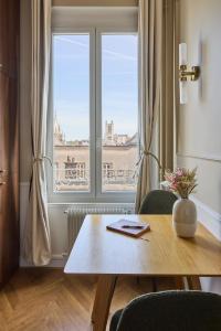 a dining room with a table and a window at Haussmannien calme hyper-centre in Troyes
