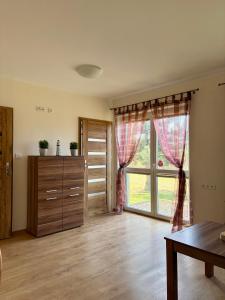 a living room with a large window and a table at Tomaszówka in Sarbinowo